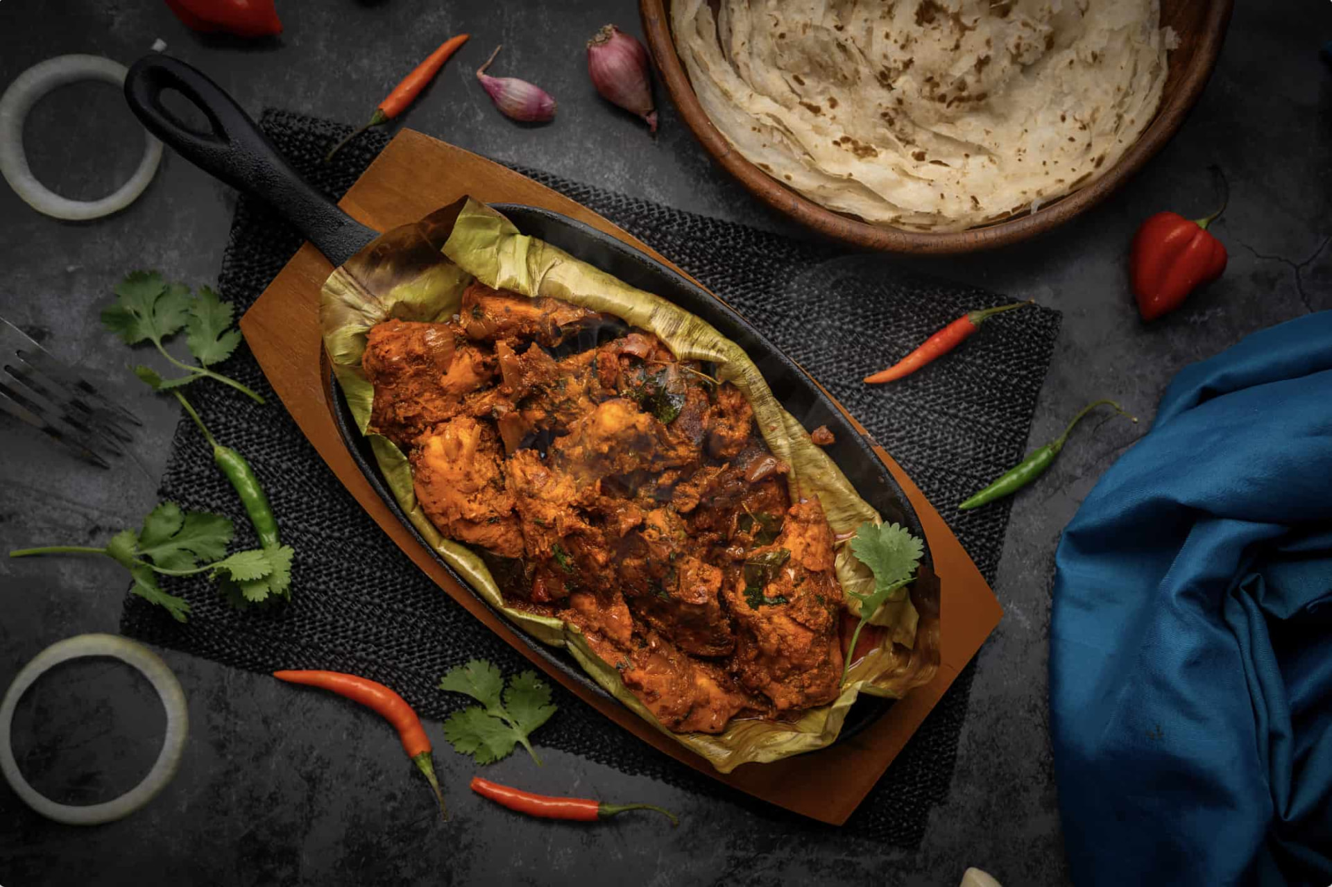 Kerala feast of chicken curry, Malabar biryani and parotta on a banana leaf